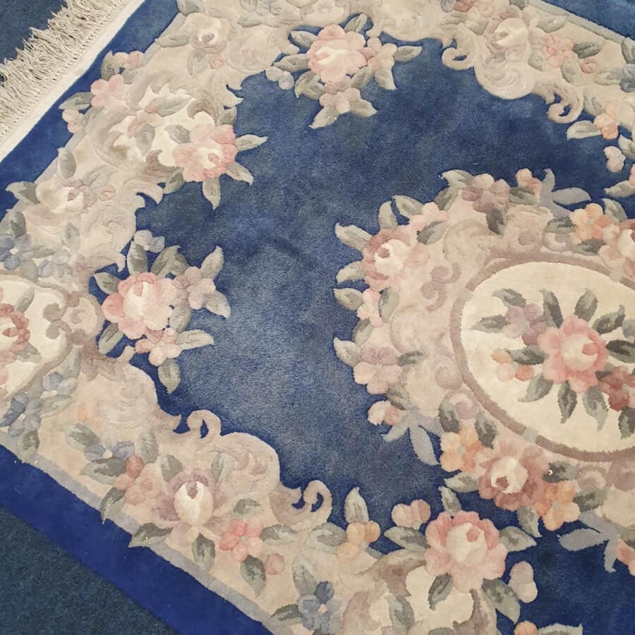 Faded blue floral Chinese rug before professional rug cleaning